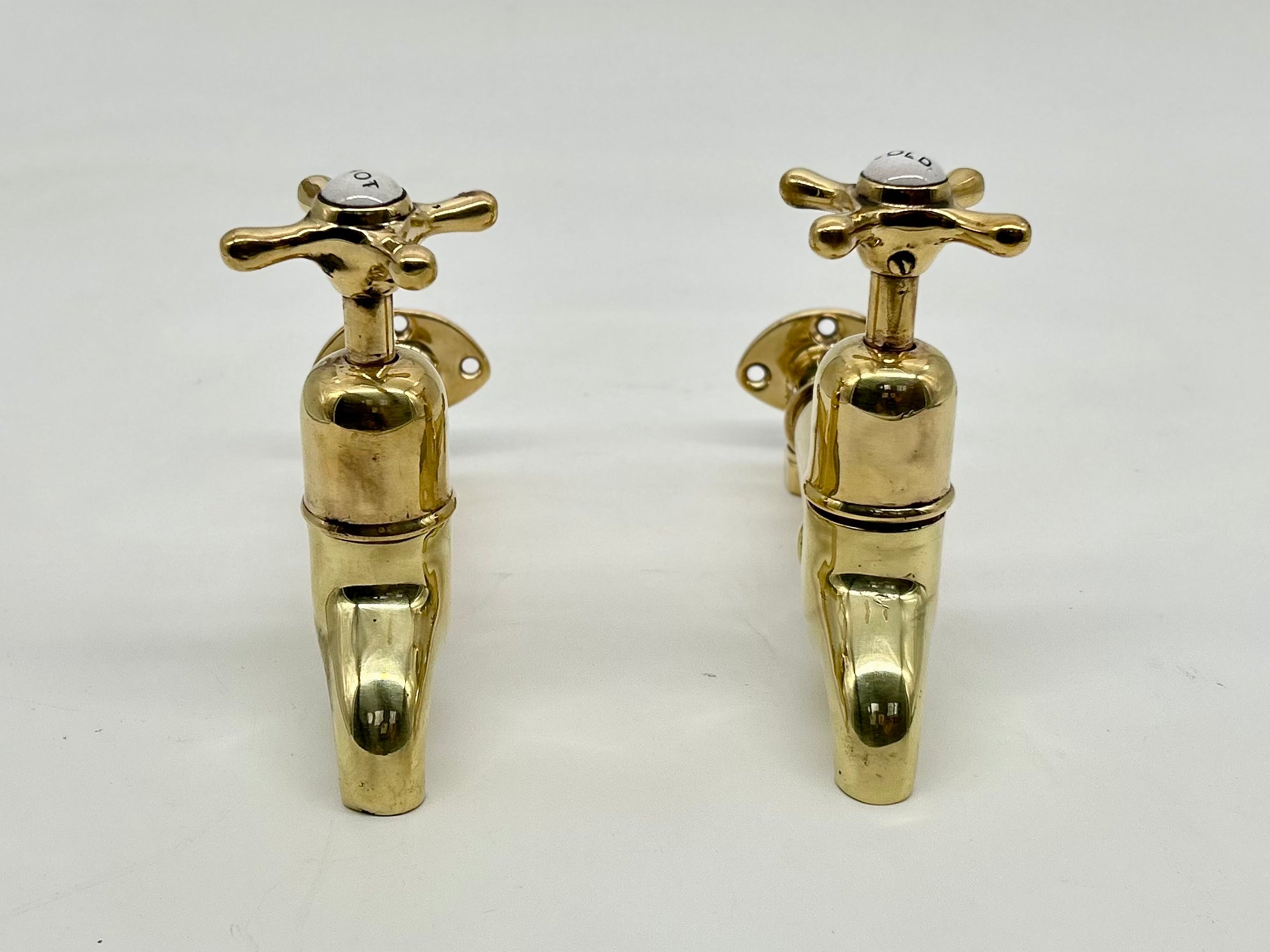 A Pair of Wall-Mounted Kitchen Sink Bib Taps C.1920 in Unsealed Polished Brass Finish.