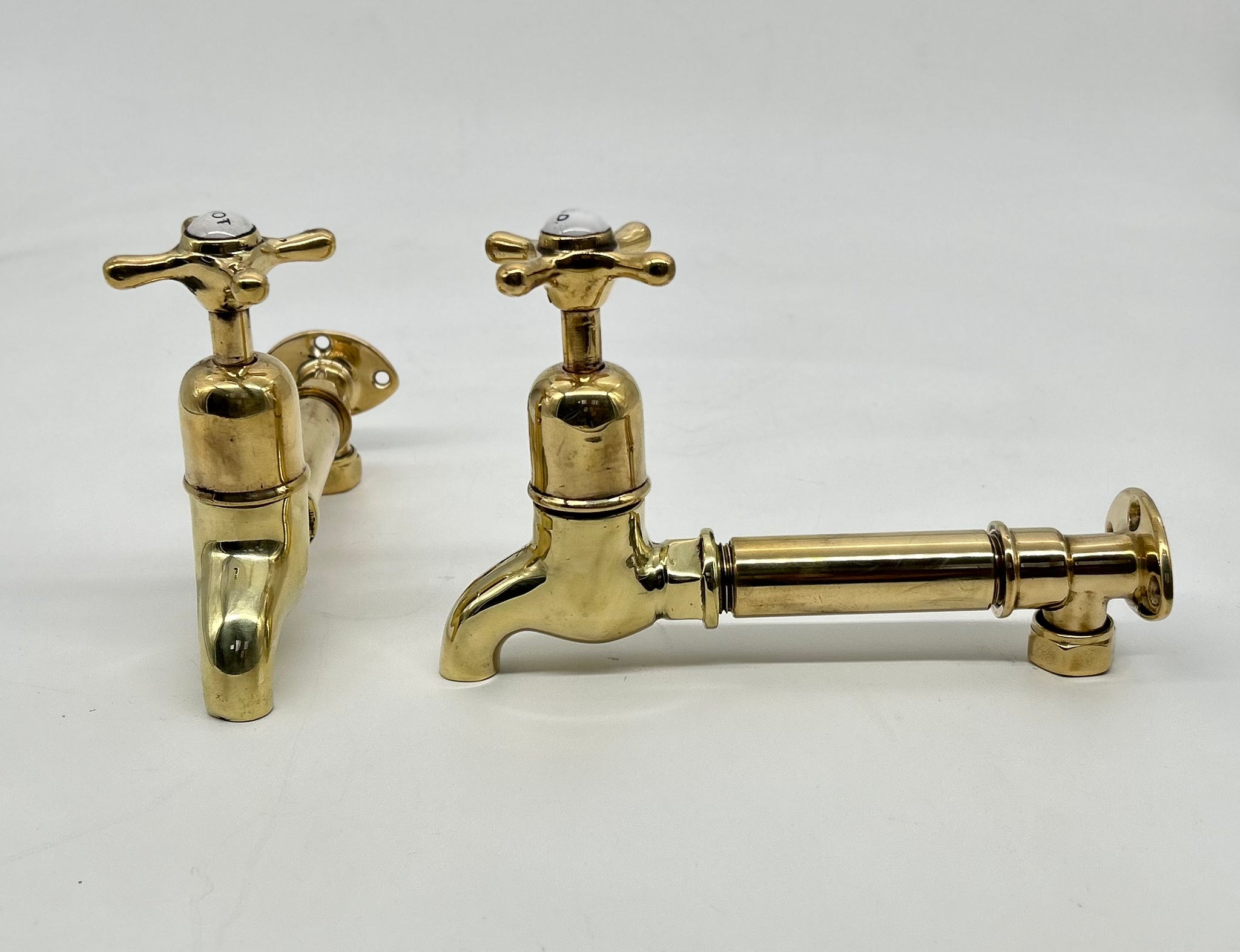 A Pair of Wall-Mounted Kitchen Sink Bib Taps C.1920 in Unsealed Polished Brass Finish.